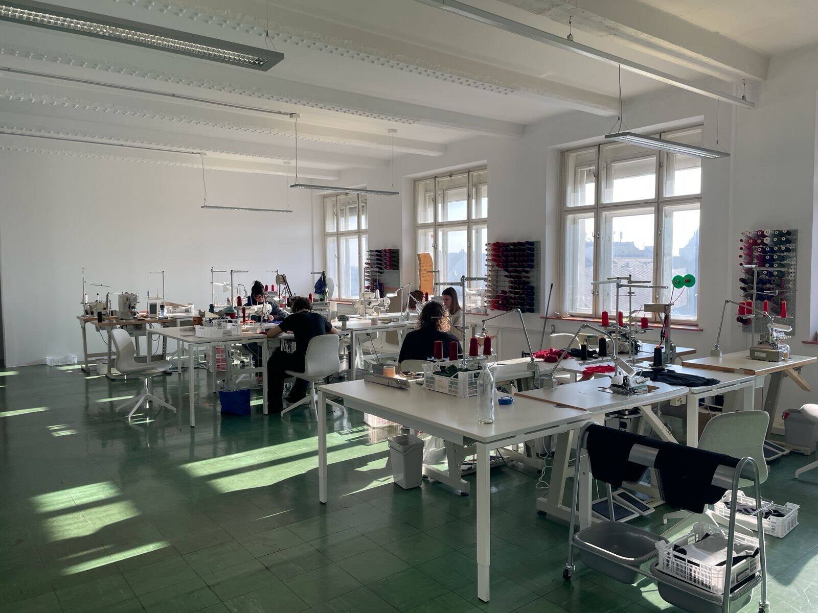 Soda Lingerie sewing room: workstations with sewing machines and thread spools in the light-filled Vienna studio